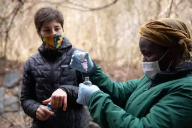 Two people conduct water quality testing while wearing precautionary face masks during the COVID-19 pandemic.